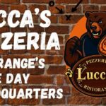 Lucca’s Pizzeria ad with bear mascot holding a pizza, text says ‘La Grange’s Game Day Headquarters.’