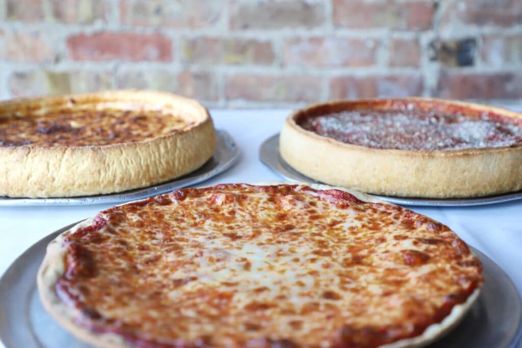 3 of Lucca's deep-dish pizzas served on a table at their restaurant locaiton in La Grange.