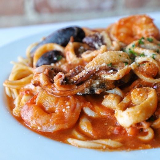 Pasta Puttanesca made with linguini and served with a tomato based sauce with calamari, shrimp, bay scallops, mussels, Italian gaeta olives & capers.